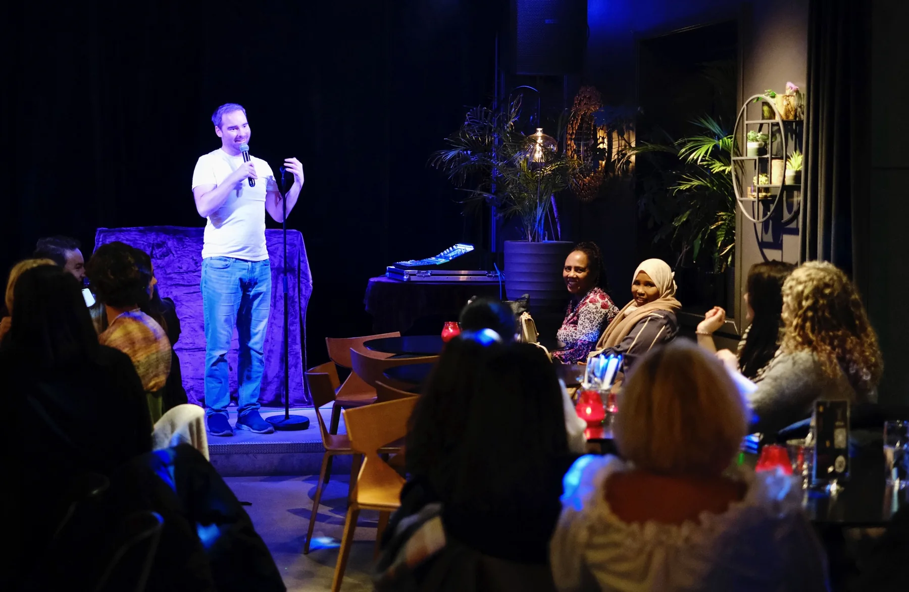 Eirik performing to a seated comedy-club audience